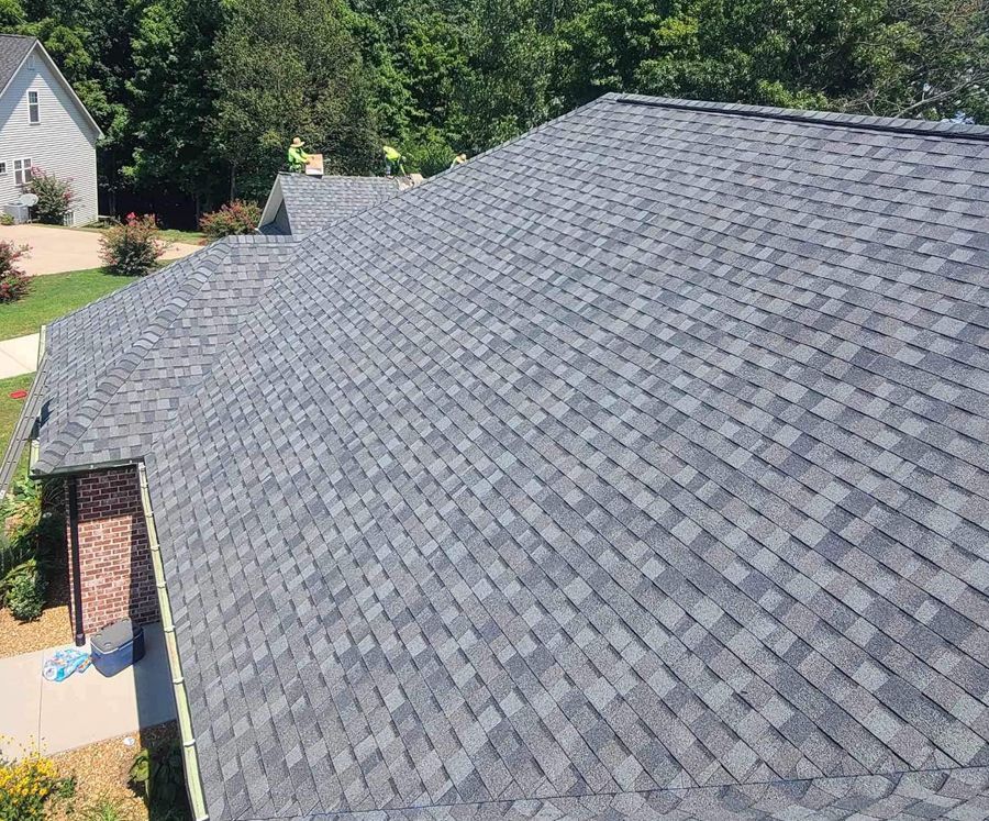 An aerial view of a house with a gray shingle roof.
