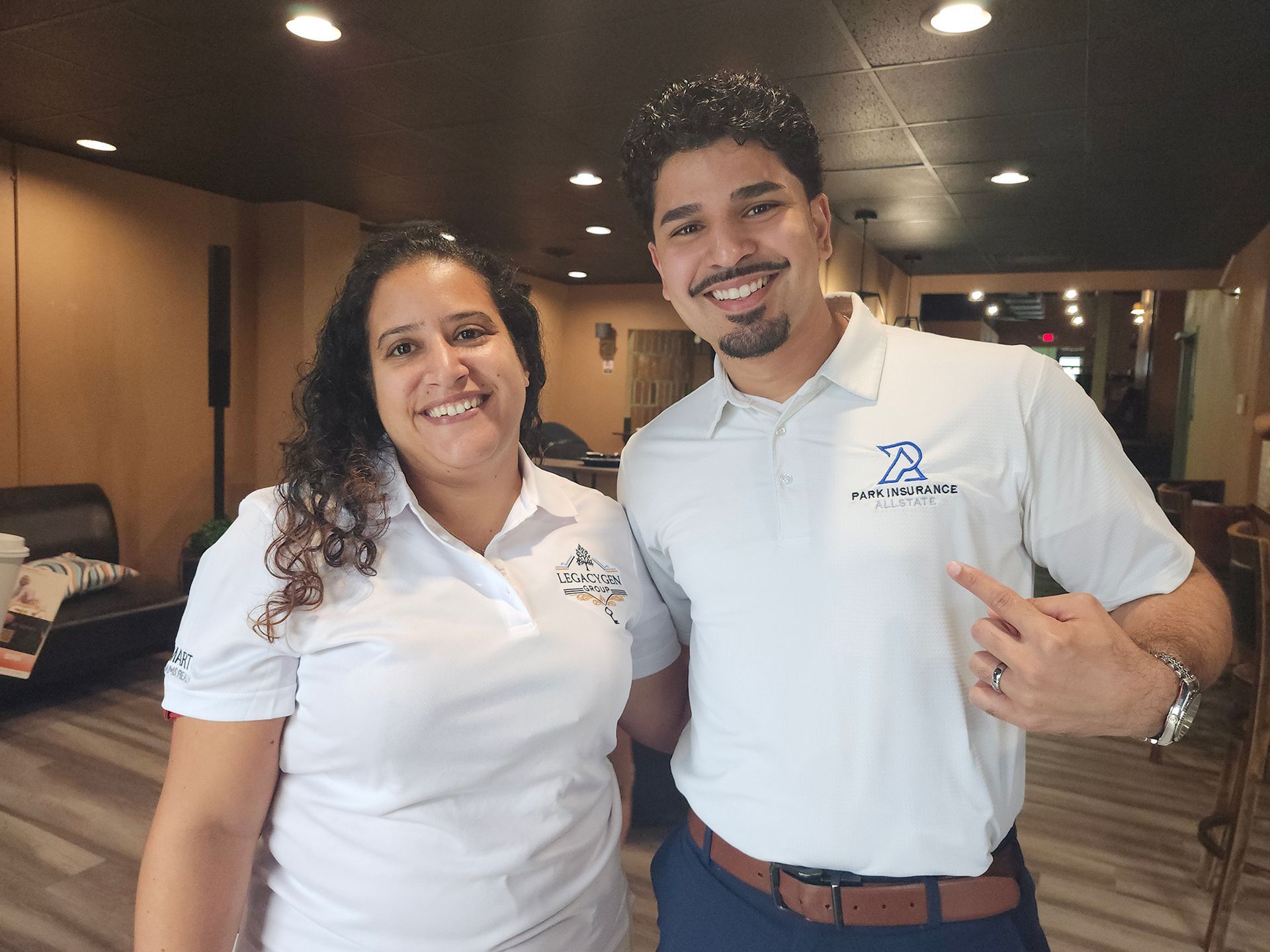 Two people in white polo shirts smiling at the camera