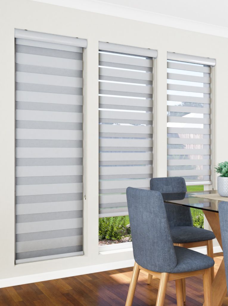 A dining room with a table and chairs and blinds on the windows.