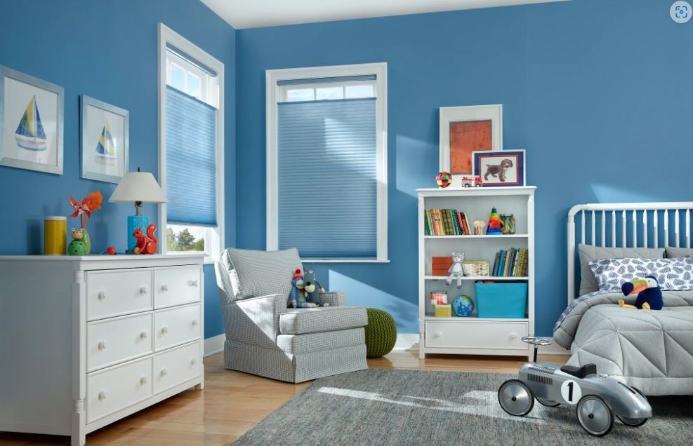 A child 's bedroom with blue walls and white furniture