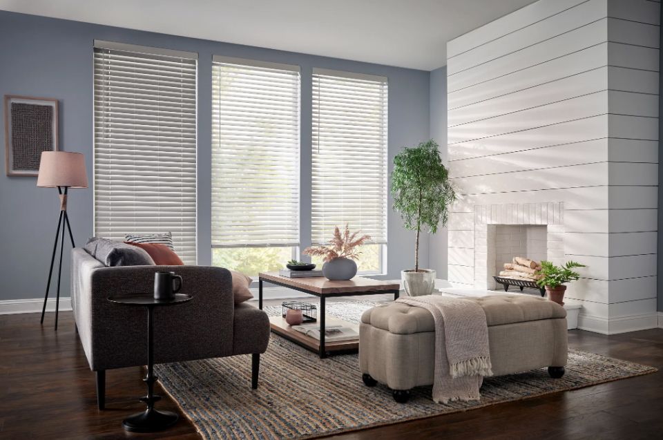 A living room with a couch , coffee table , ottoman and fireplace.