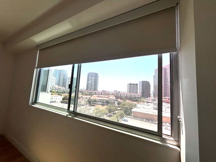 Interior view of a room with a long window and city skyline outside