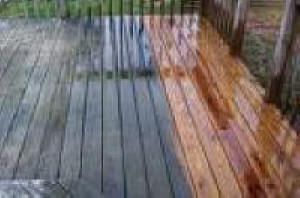 A wooden deck is being cleaned with a pressure washer.