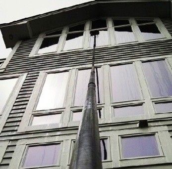 A large building with a lot of windows and a pole in front of it.