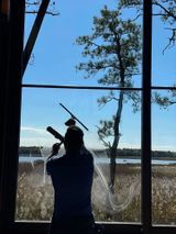A man is cleaning a window with a squeegee.