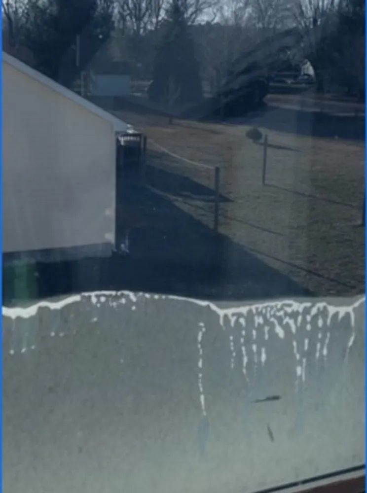 A window with a reflection of a house in it