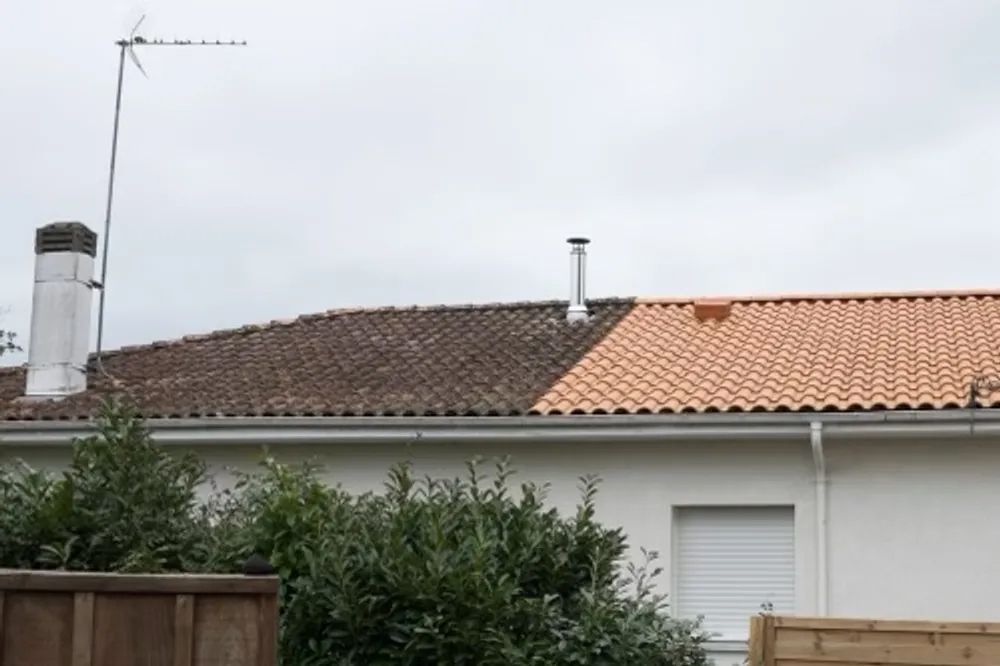 A house with a tiled roof and a chimney.
