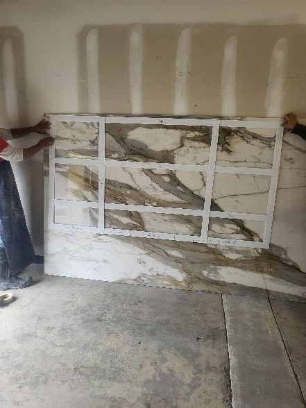 Two people holding a large marble slab