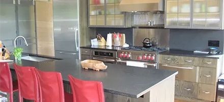 A kitchen with stainless steel appliances and a black counter top