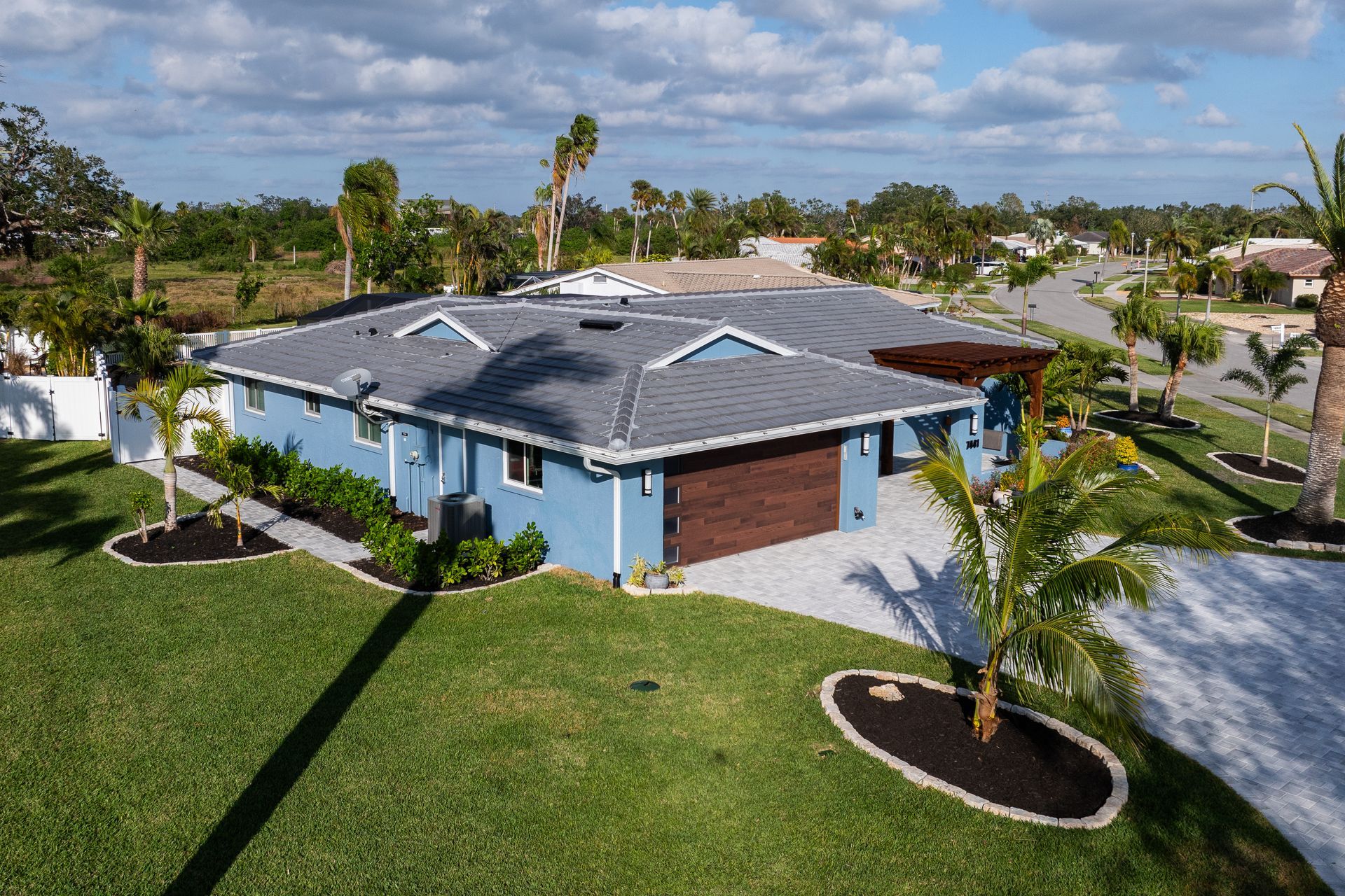 An aerial view of a blue house with a gray roof