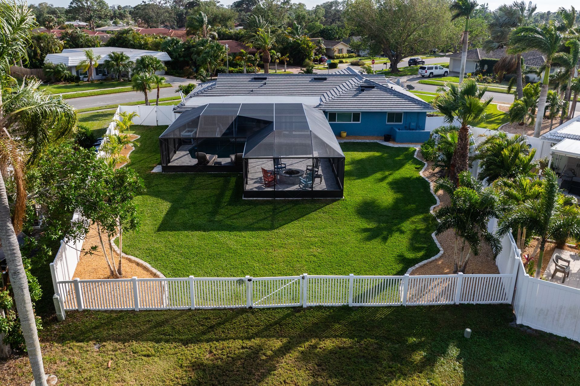 An aerial view of a house with a screened in porch and a large lawn.