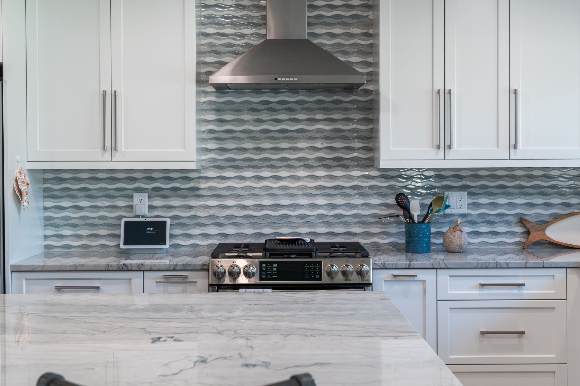 A kitchen with white cabinets and a stove top oven.