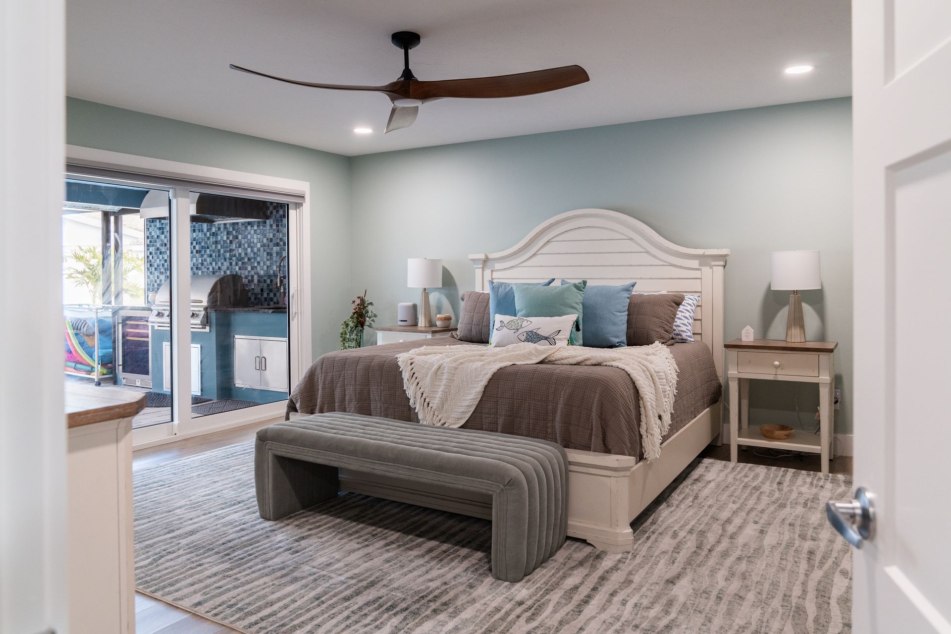 A bedroom with a king size bed and a ceiling fan.
