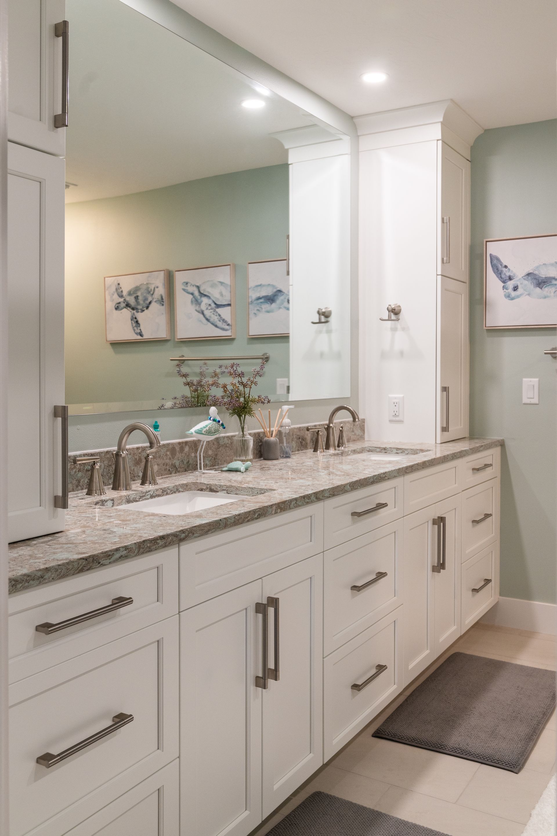A bathroom with two sinks and a large mirror.