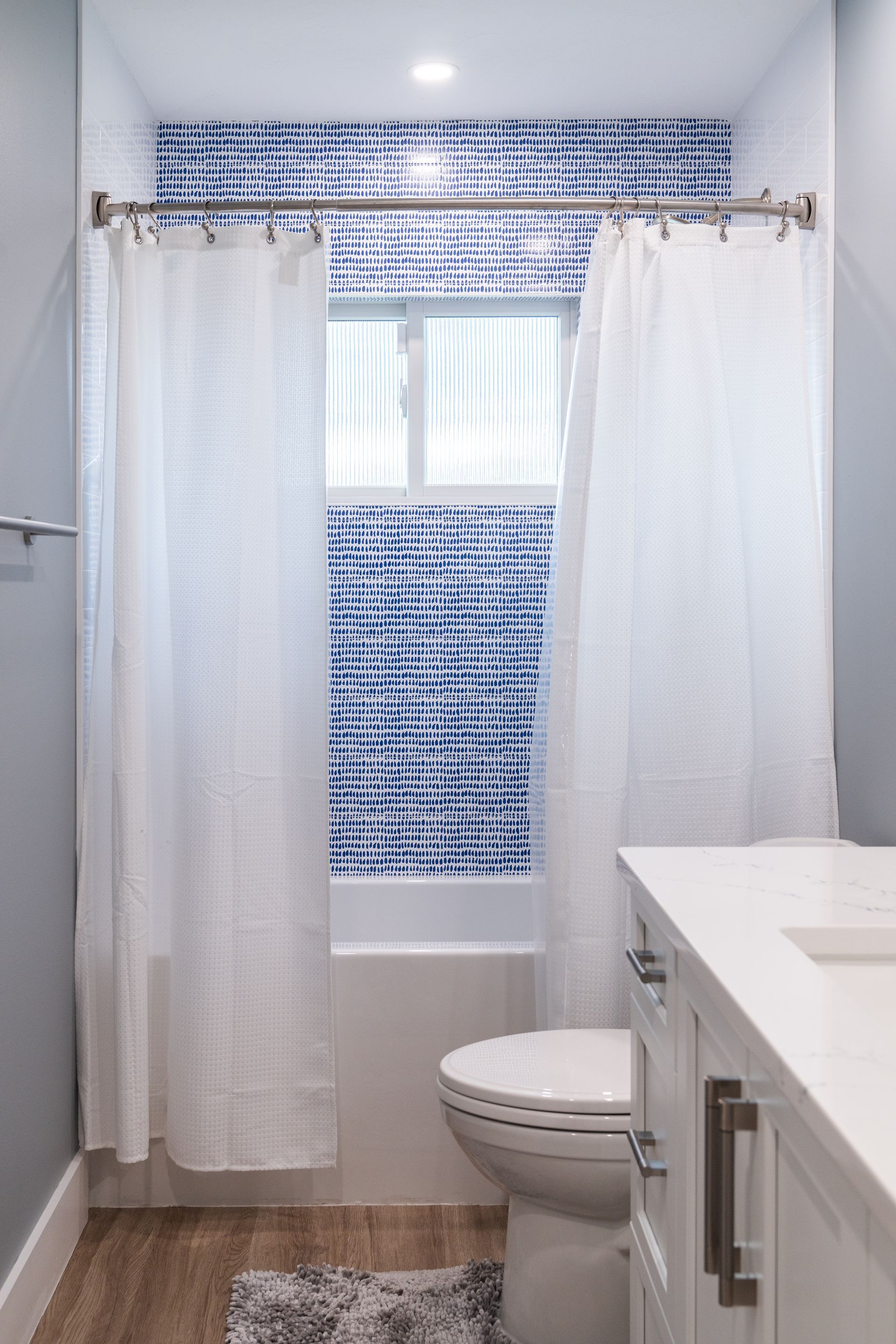 A bathroom with a toilet, sink, and shower curtain.