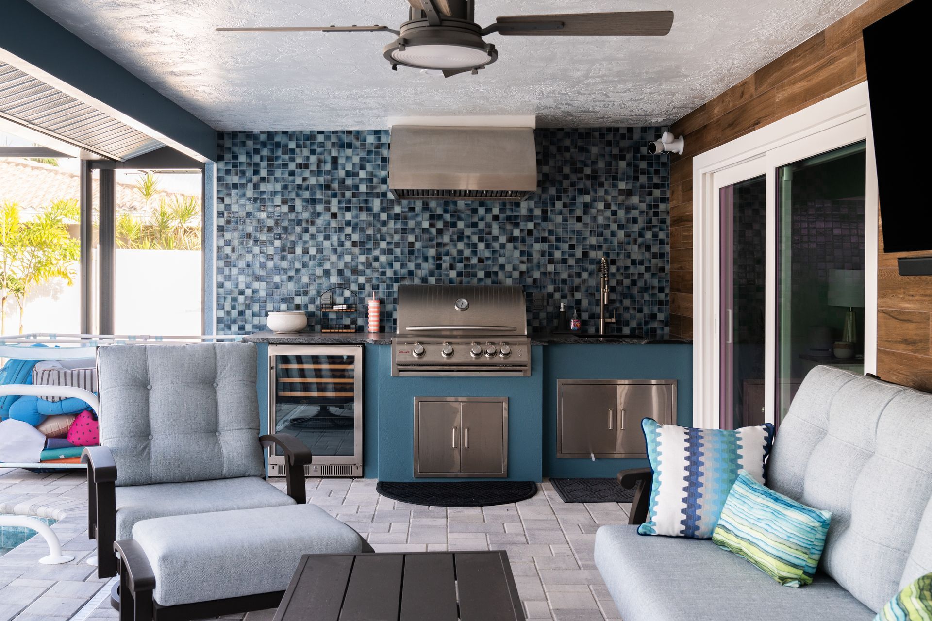 A living room with a couch, chairs, and a grill.