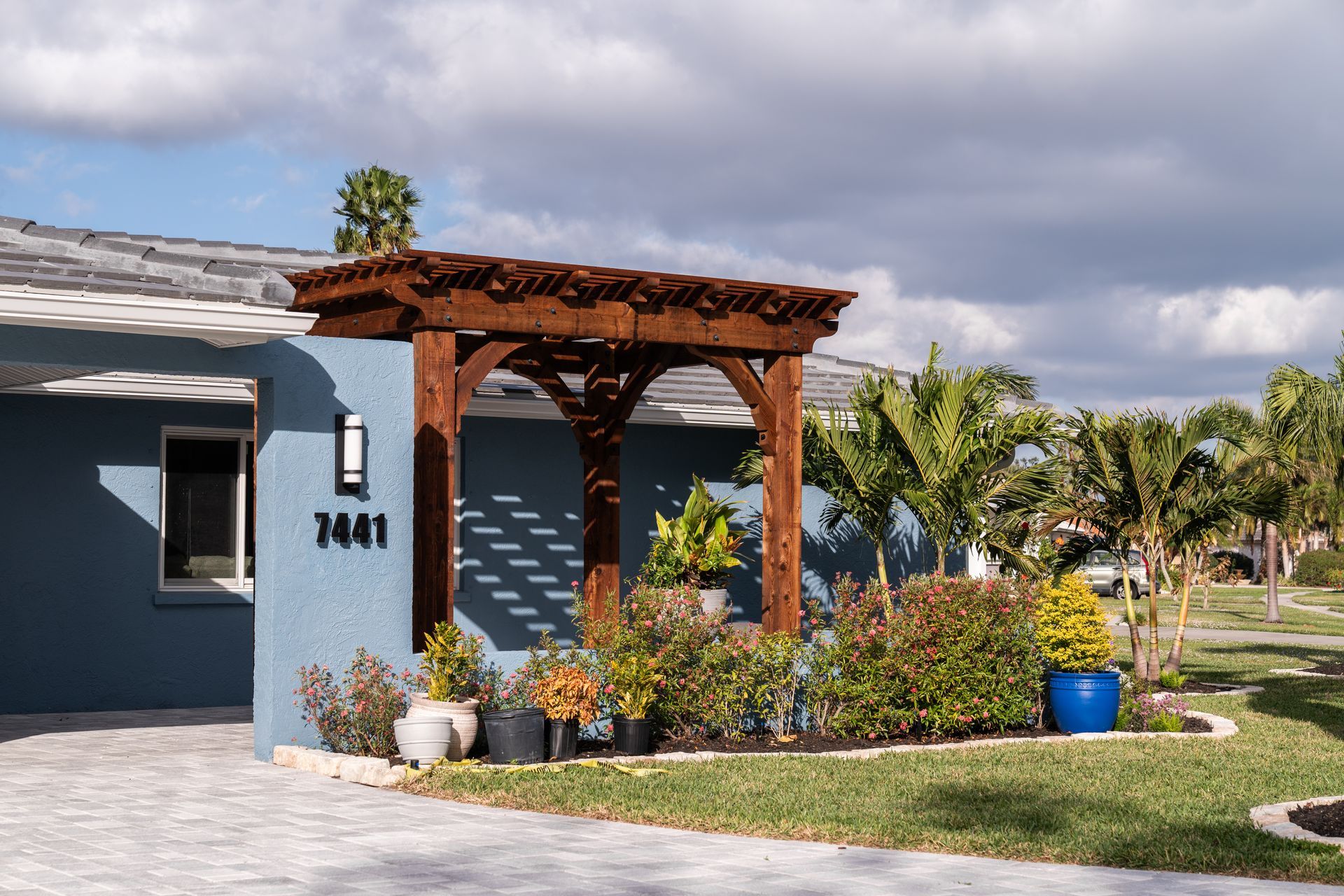 A blue house with a pergola on the front