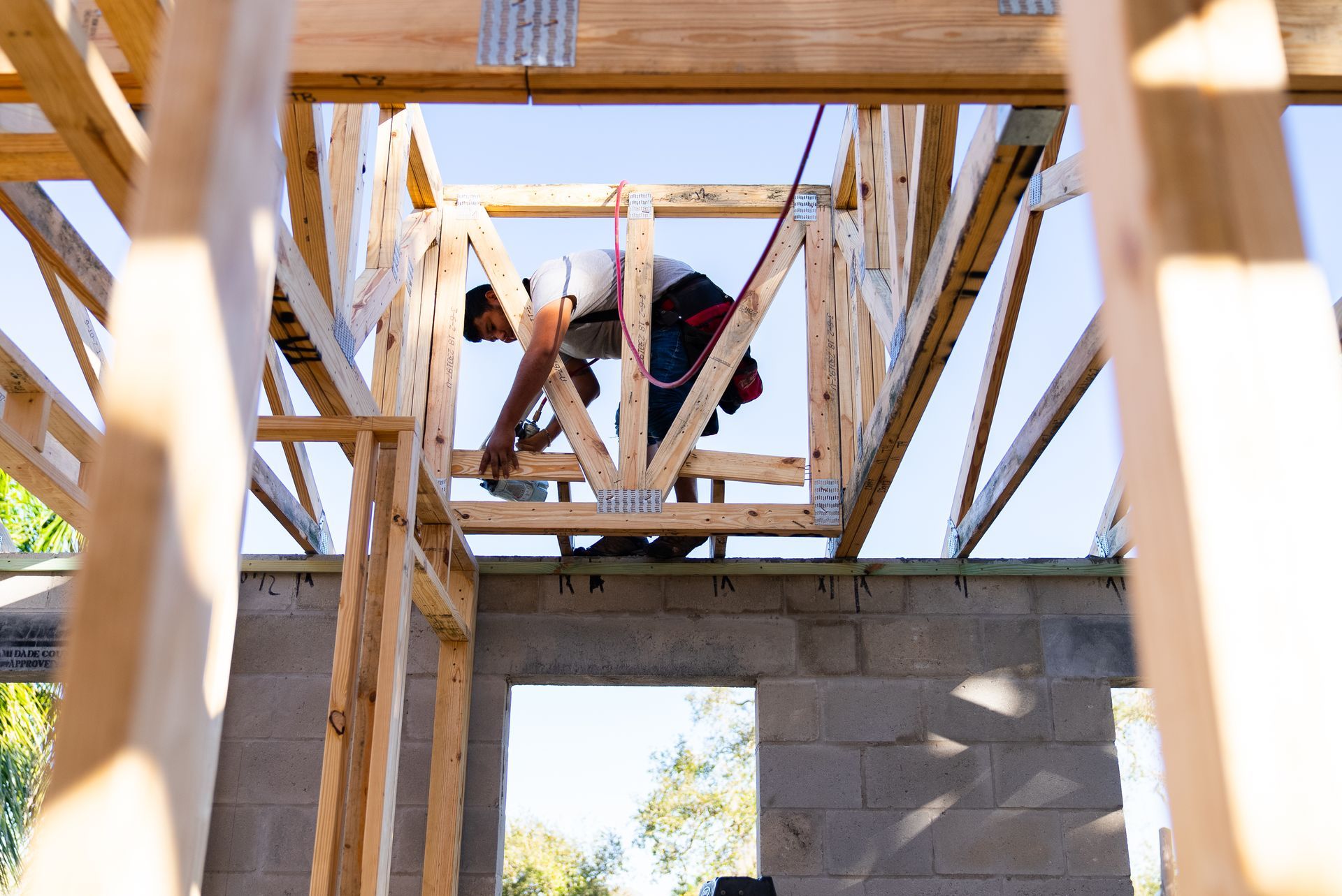 A man is working on the roof of a house under construction.