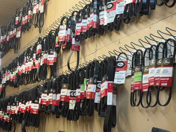 Rows of black automotive belts hanging on a wall, with price tags attached.