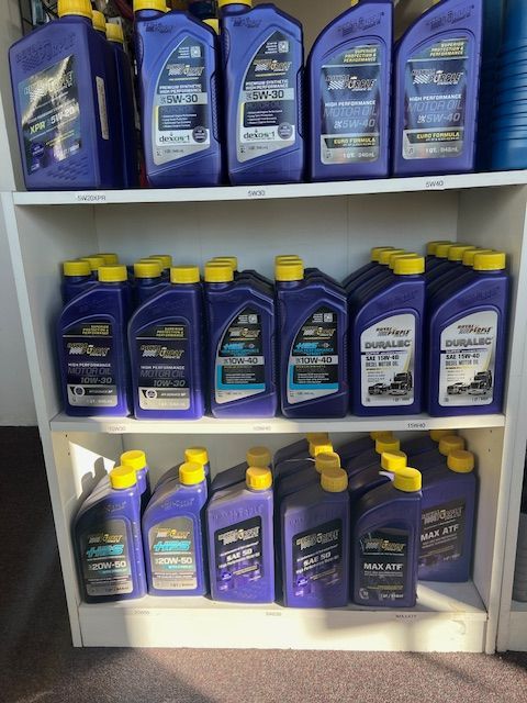 A shelf full of purple and yellow bottles of oil.