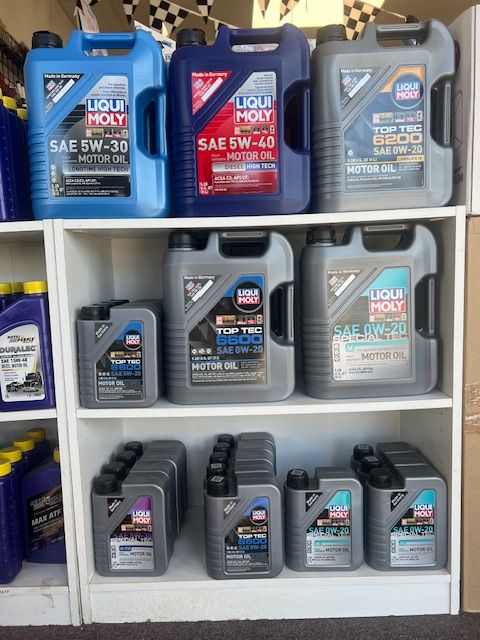Several bottles of liqui moly motor oil are on a shelf.