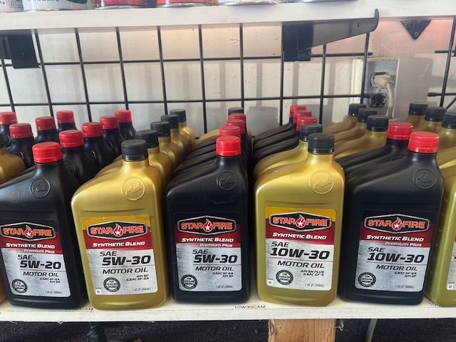 Several bottles of oil are lined up on a shelf.