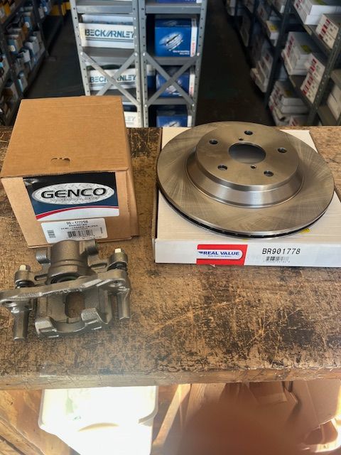 A brake caliper and a brake rotor are on a table.