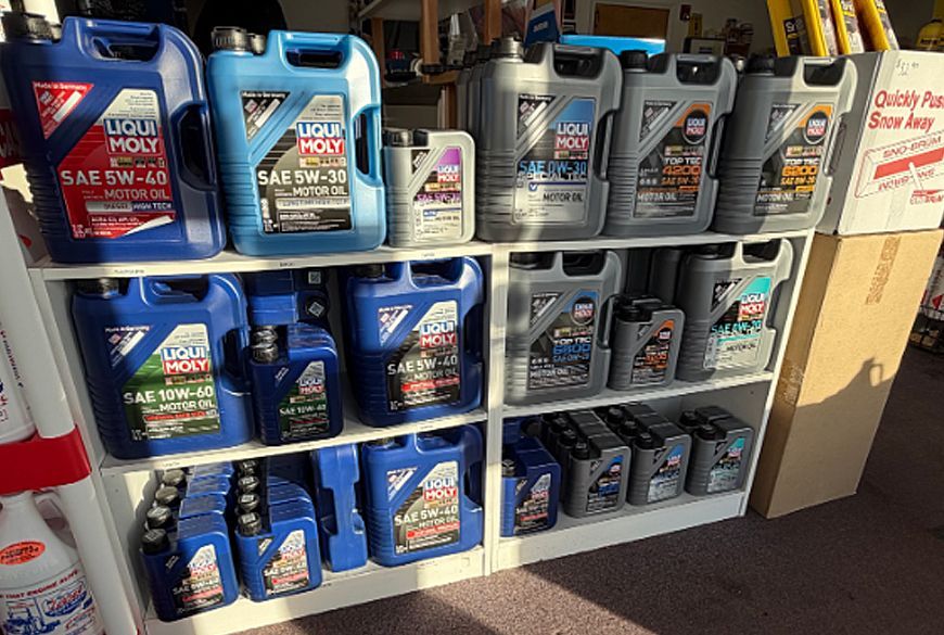 Shelves of motor oil containers in various sizes, predominantly blue and silver.