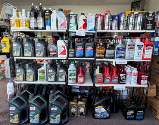 Shelves filled with various oil bottles, containers in a store.
