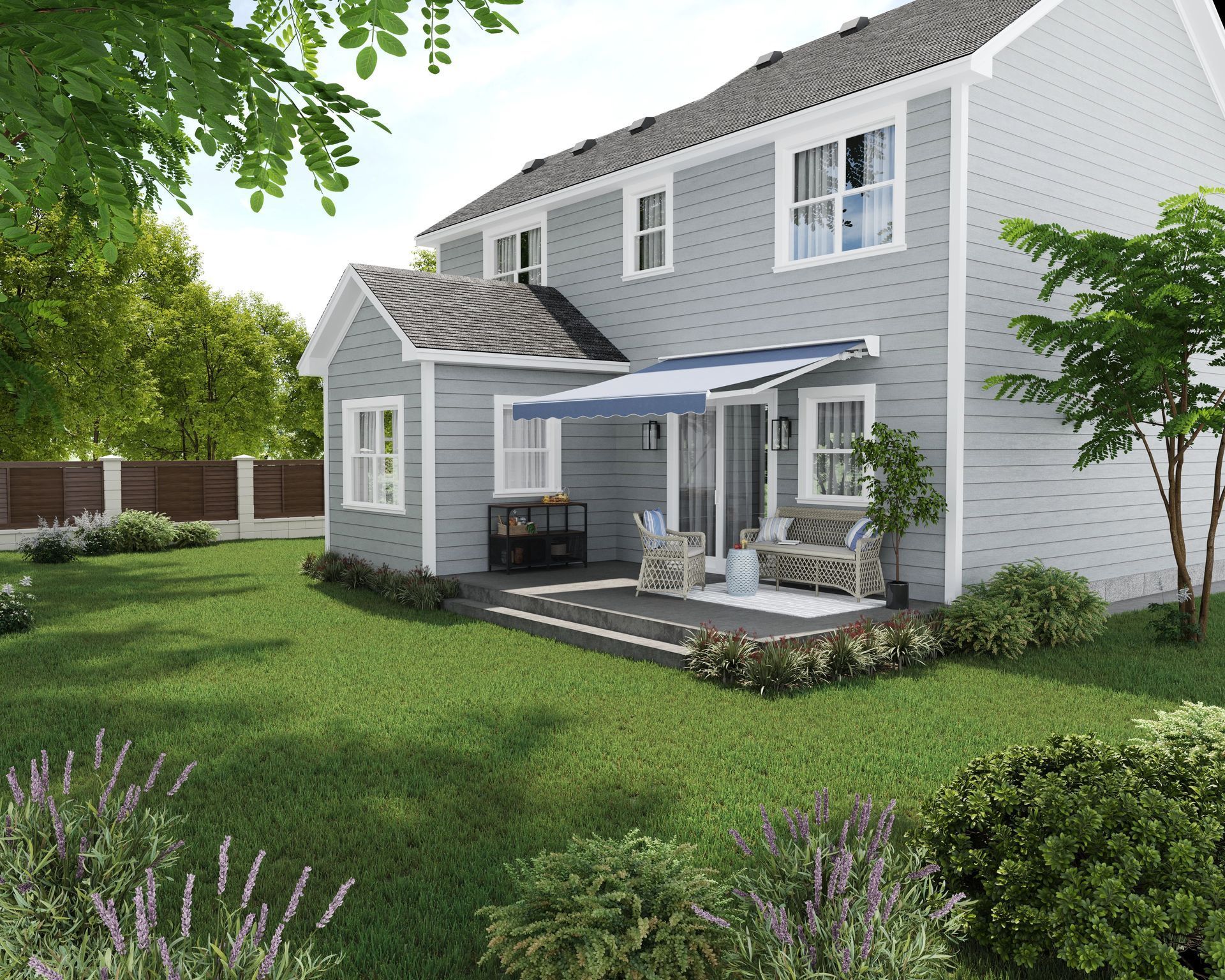 Rear view of a two-story gray house with a deck and blue awning, set in a grassy yard.