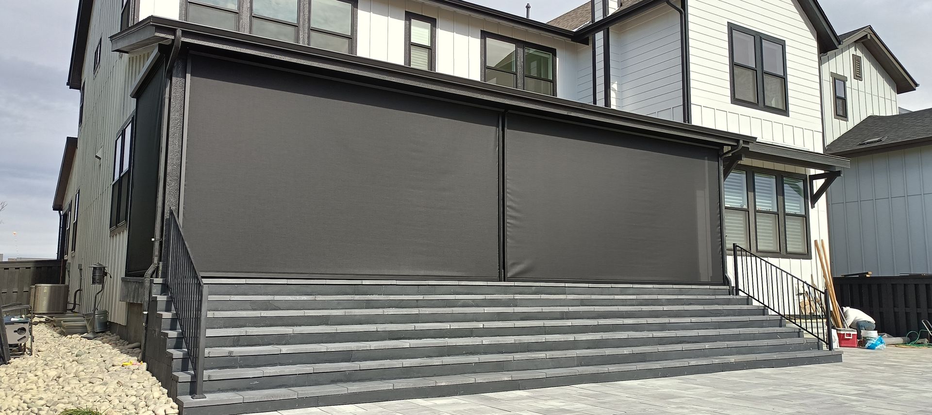 Closed gray storefront with metal shutters and steps in front of a building