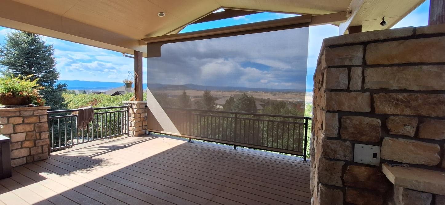 Covered patio with stone columns, tiled floor, and an ocean view beyond the railing.