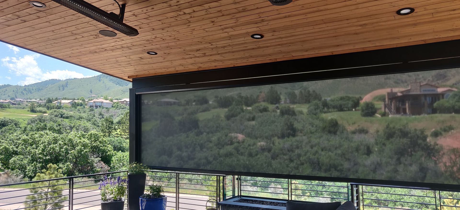Shaded balcony with panoramic mountain and valley view through a mesh screen