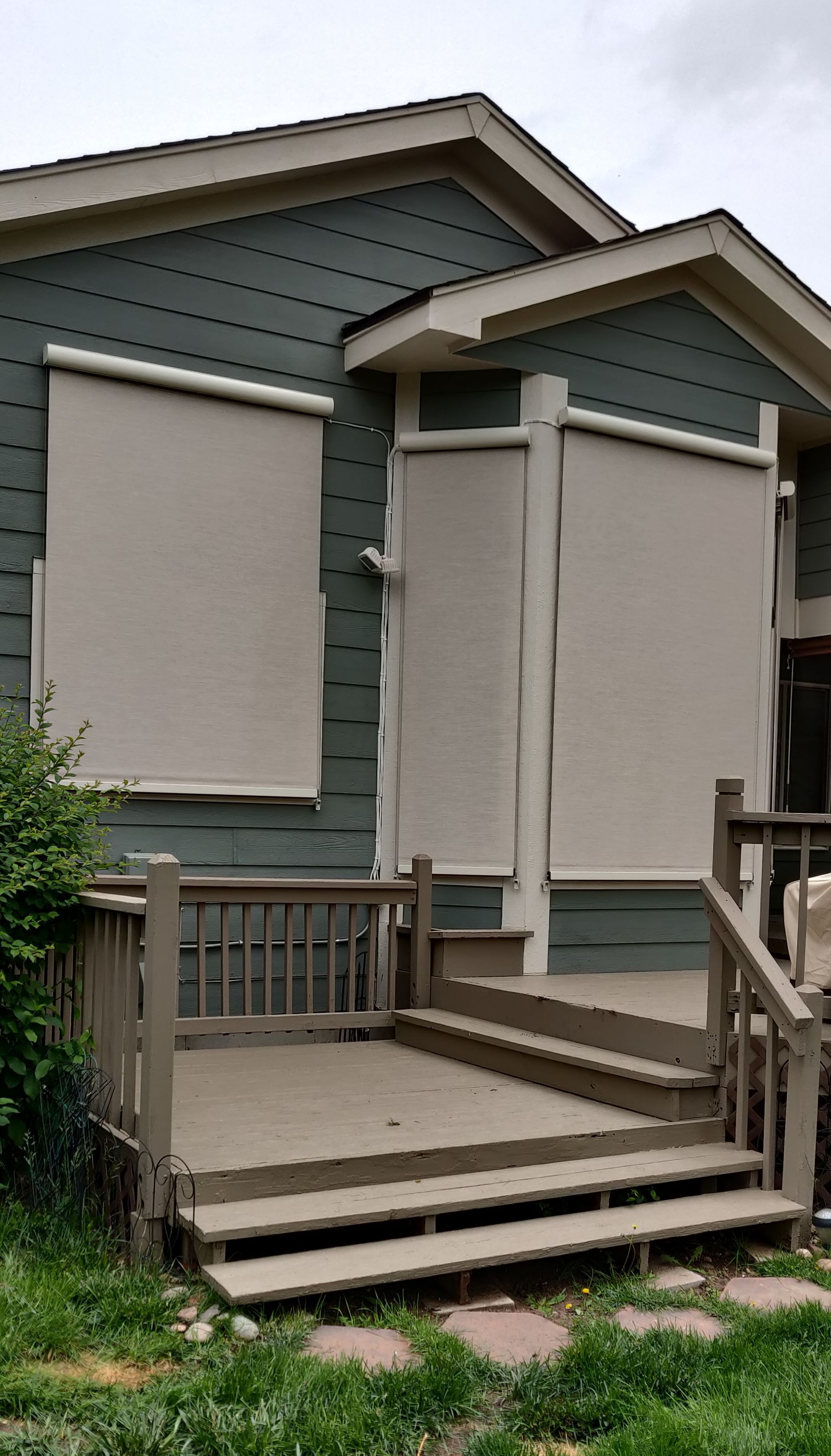 House with boarded-up windows and a small front porch, viewed from the yard