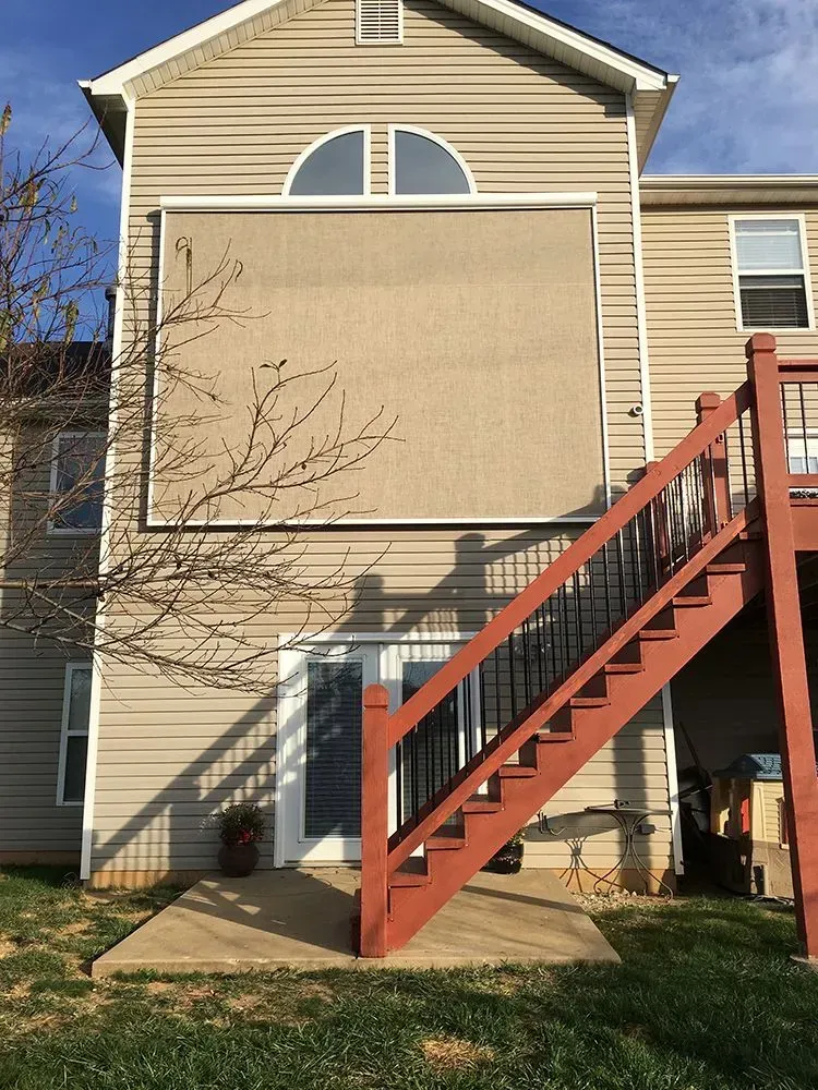 House exterior with a large boarded-up window and red staircase on the side