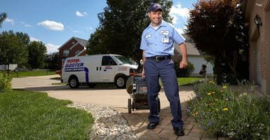 A man in a blue shirt is standing in front of a white van.