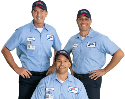Three men wearing blue shirts and hats are posing for a picture