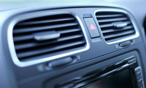 Car dashboard with air vents, hazard light button, and a screen.