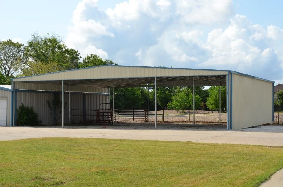 A large metal building with a fence in front of it