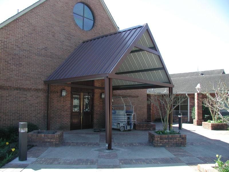 A brick building with a brown awning over the entrance