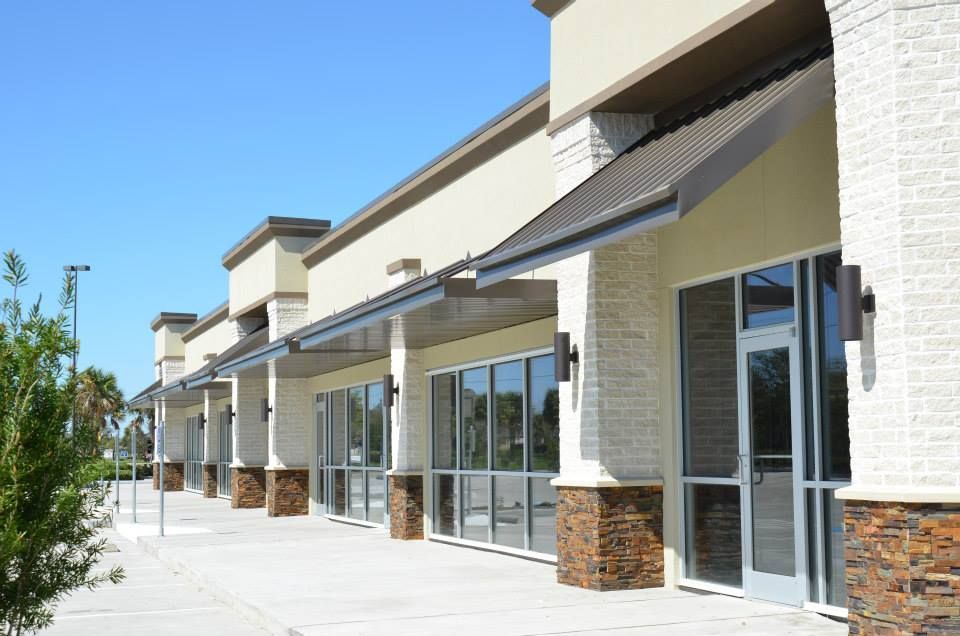 A row of empty store fronts with awnings on a sunny day.