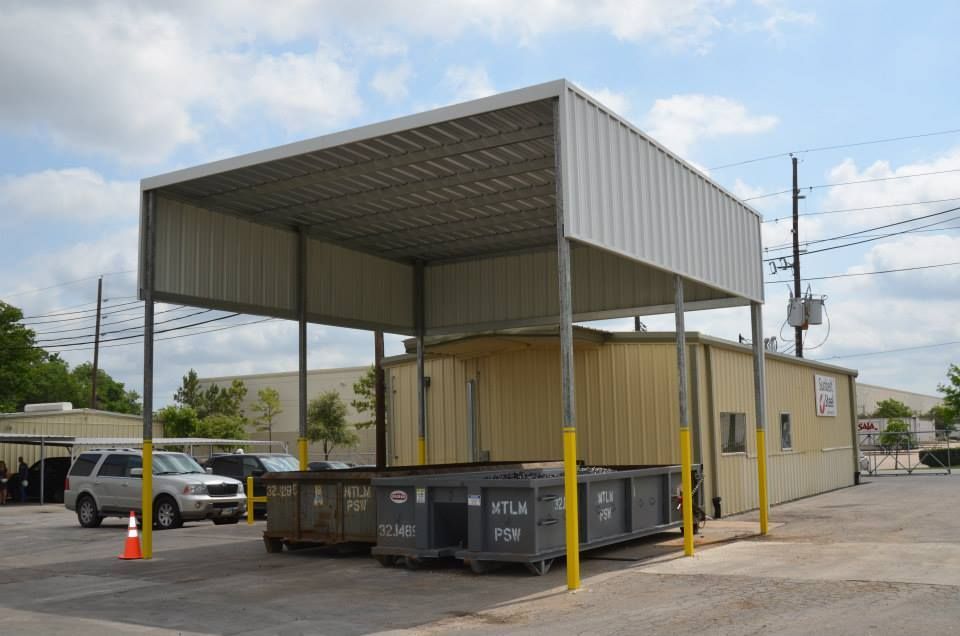 A building with a canopy over it and a dumpster in front of it.