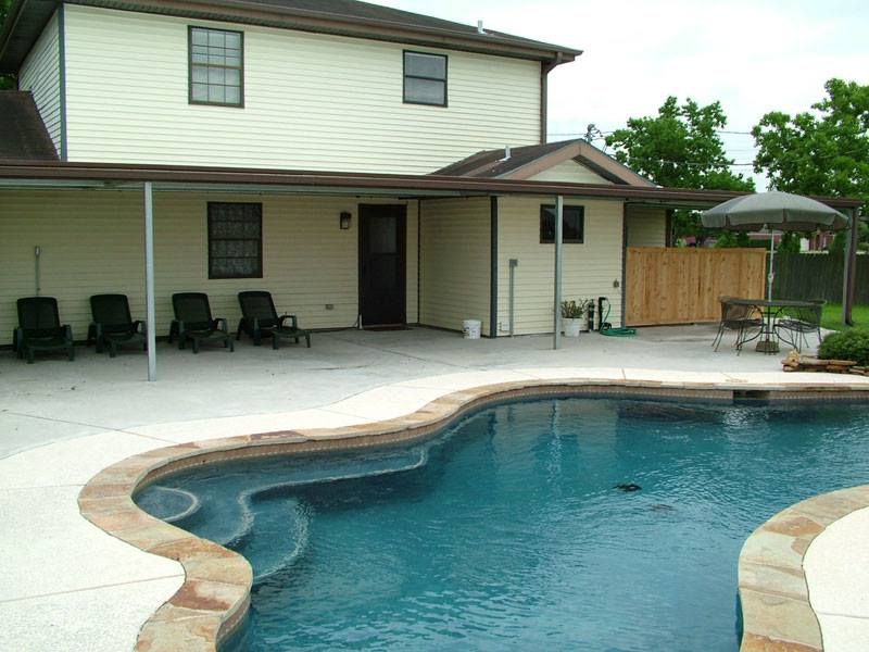 A house with a large swimming pool in front of it