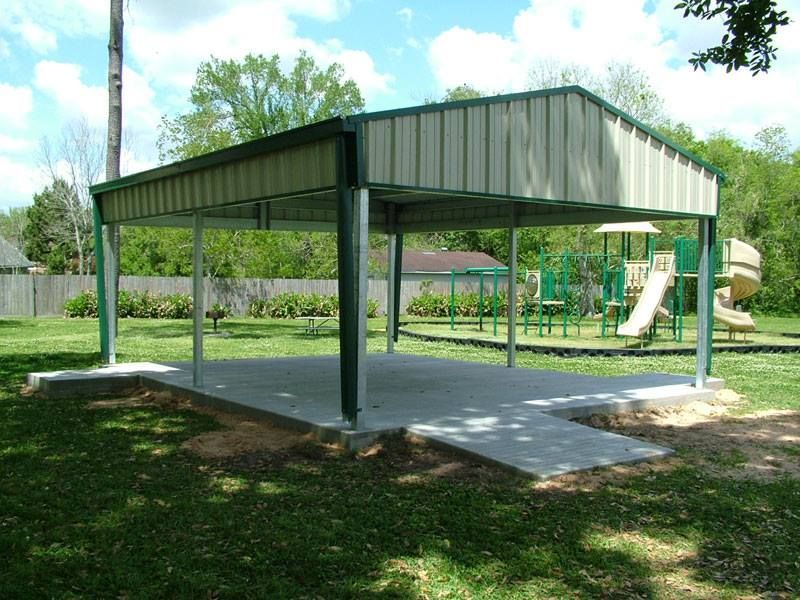 A pavilion in a park with a playground in the background