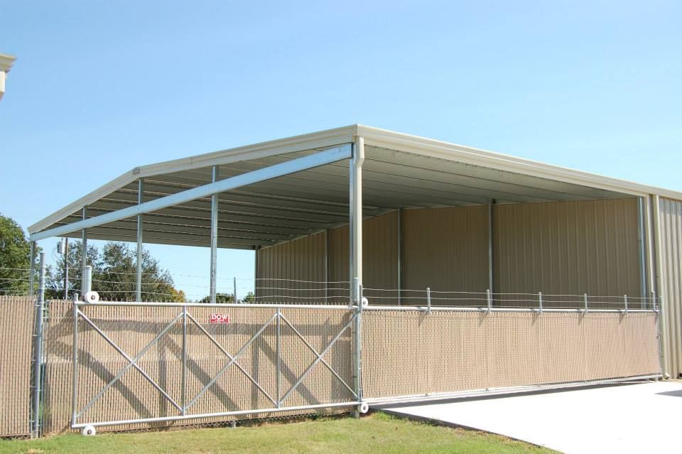 A large metal building with a fence around it