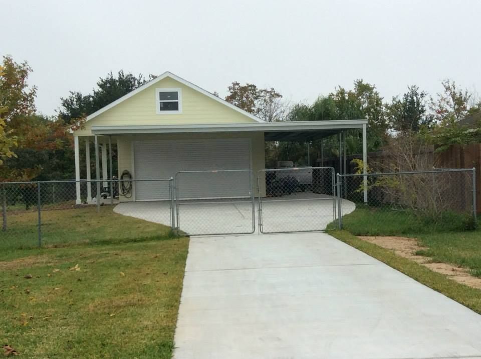 A driveway leading to a garage with a canopy over it