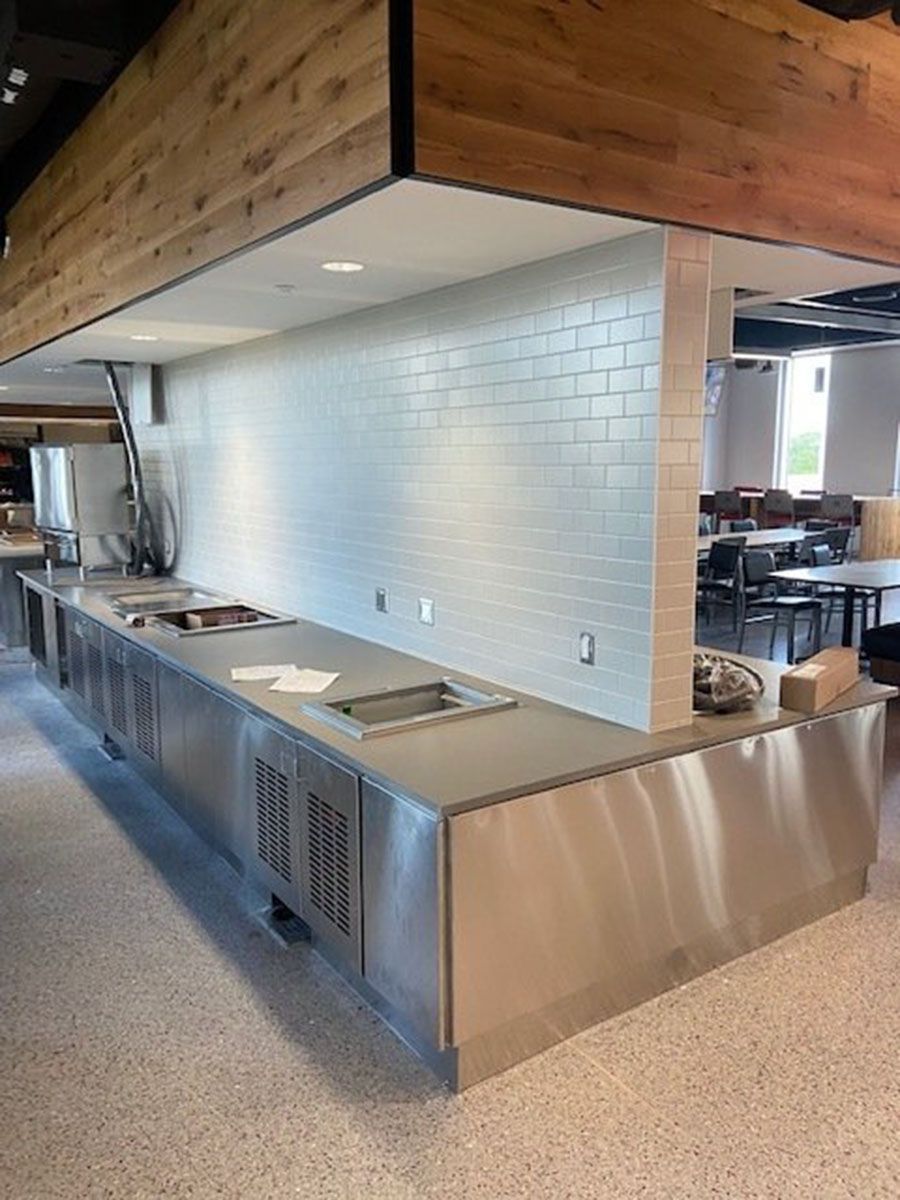 A kitchen with stainless steel countertops and a wooden ceiling