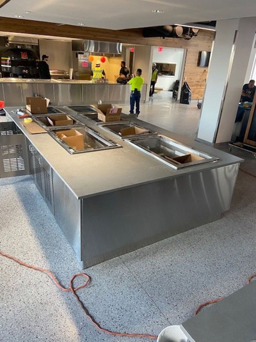 A large stainless steel counter is being built in a restaurant