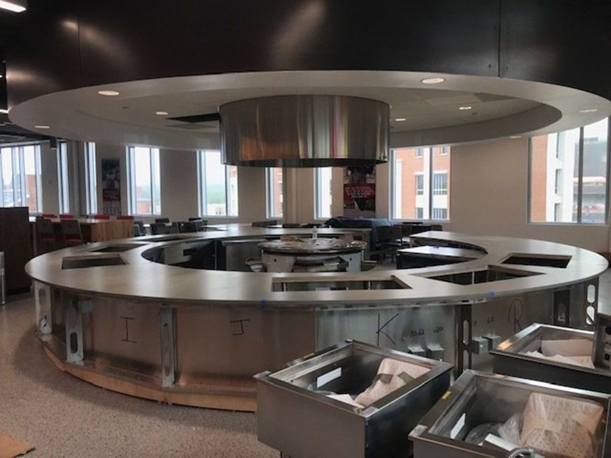 A kitchen with a round countertop and a stainless steel hood