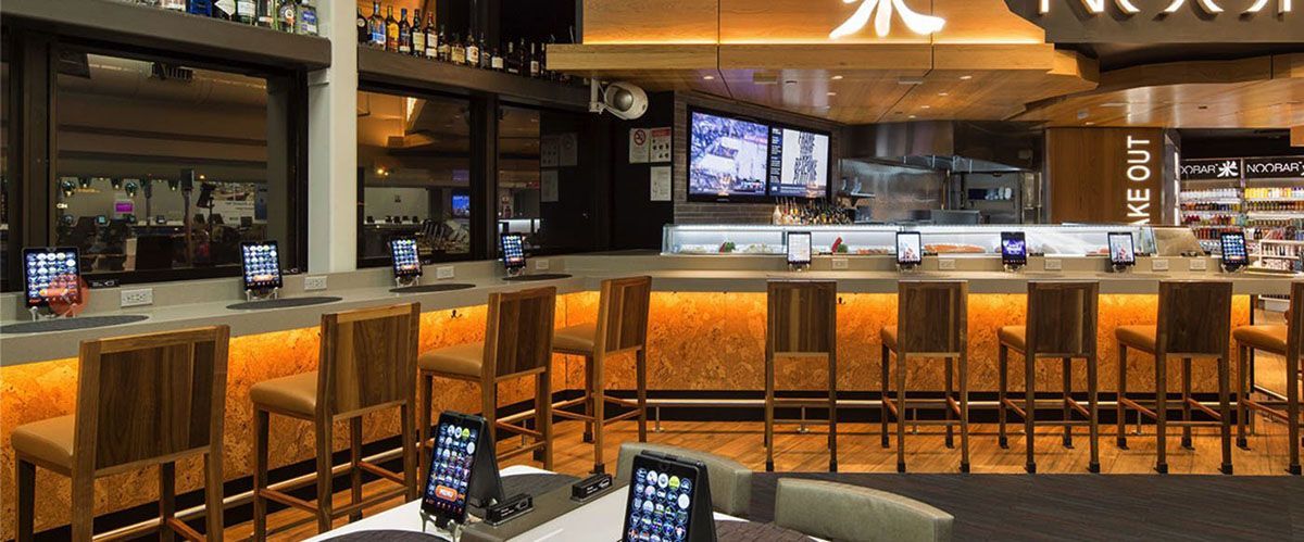 A restaurant with a long bar and tables and chairs